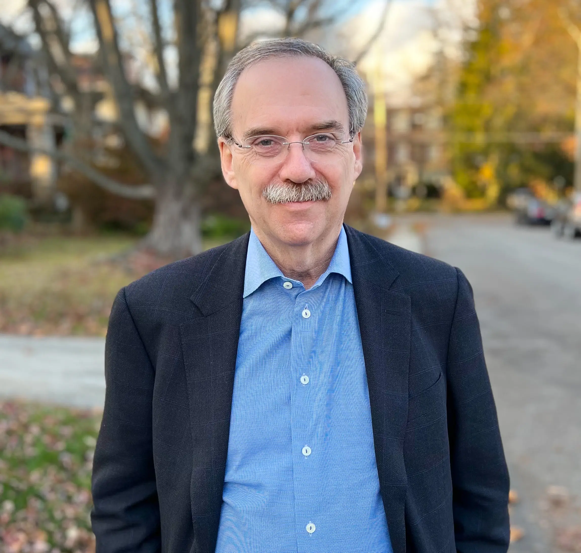 Headshot of Lee Fleisher on an outdoor background with a tree.